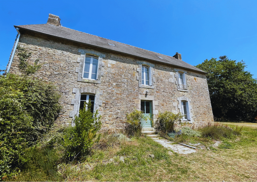vue extérieure de La Maison Rosporden avec sa jolie façade ensoleillée, 5 fenêtres et une porte.