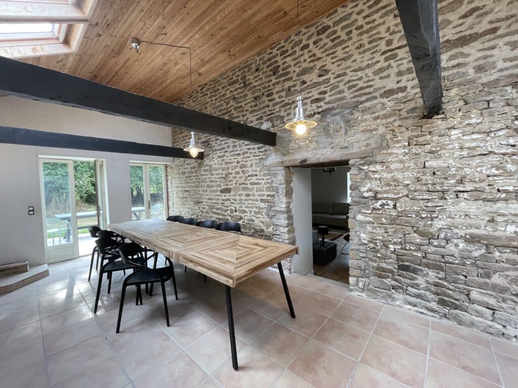 salle à manger cuisine de La Maison Rosporden. Une grande pièce de 30 mètres carrés avec une grande tablée permettant de réunion 14 personnes à table et de cuisiner de bons petits plats.