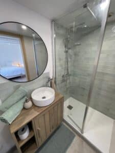 photo d'une des 5 salles de bains de la maison avec douche, wc et lave main